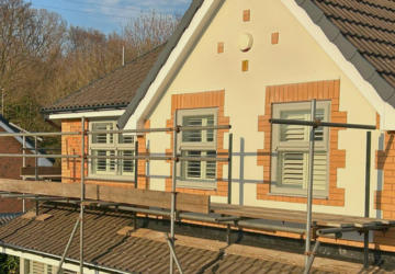 Scaffolded cream and brick property during fascia and soffit replacement project
