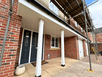 White UPVC porch ceiling and cladding installation on a modern red brick house