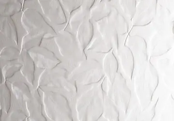 Textured white wall with a pattern resembling leaves.