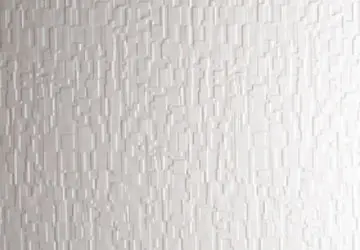 Textured white wall with a pattern of small vertical and horizontal lines.