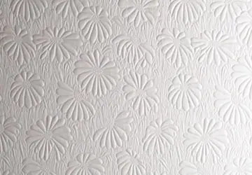 Embossed floral pattern on a white textured surface.
