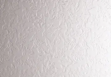 Textured white wall with a subtle leaf pattern.