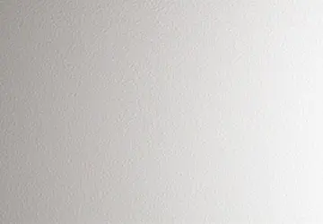 Plain, textured wall with subtle gradients from light to darker shades of gray.