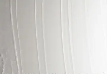 Textured white surface with subtle lines and varying shades of light.