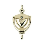 Brass door knocker with a central ring and decorative elements, mounted on a flat surface.