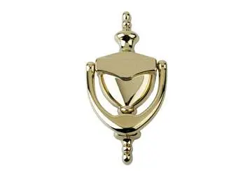 Brass door knocker in a traditional design mounted on a flat surface.