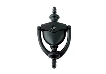 Black door knocker with an ornate design, featuring a circular grip and decorative elements.