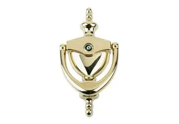 Gold door knocker with a circular design and decorative accents.