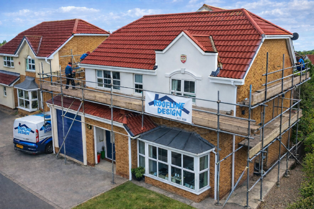Scaffolding surrounds a two-story house; workers are installing roofing while a company sign is visible.